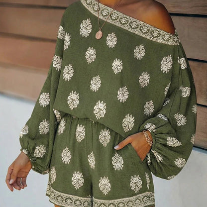 👗 50% DE DESCONTO AGORA! ✨ Macacão boémio com ombros à vista – Estampado, cintura elástica e bolsos laterais – Leve e respirável – perfeito para a praia, festivais ou viagens de verão 🌺